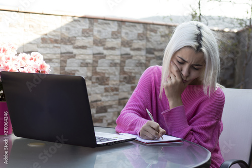 Chica terraza pensando escribiendo con el ordenador photo