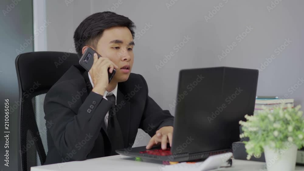 young business man talking on mobile phone and using laptop young business man talking on mobile phone and using laptop