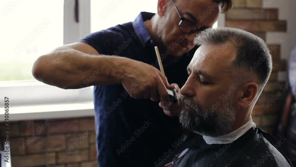 Hairdresser makes a man a haircut in the Barber shop Hairdresser makes a man a haircut in the Barber shop