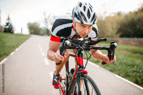 Fototapeta Naklejka Na Ścianę i Meble -  Male cyclist rides on bicycle, front view