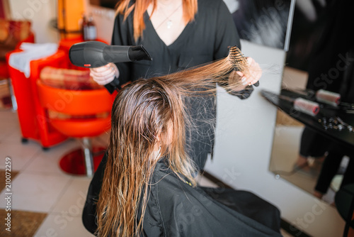 Hairdresser drying hair, female hairdressing