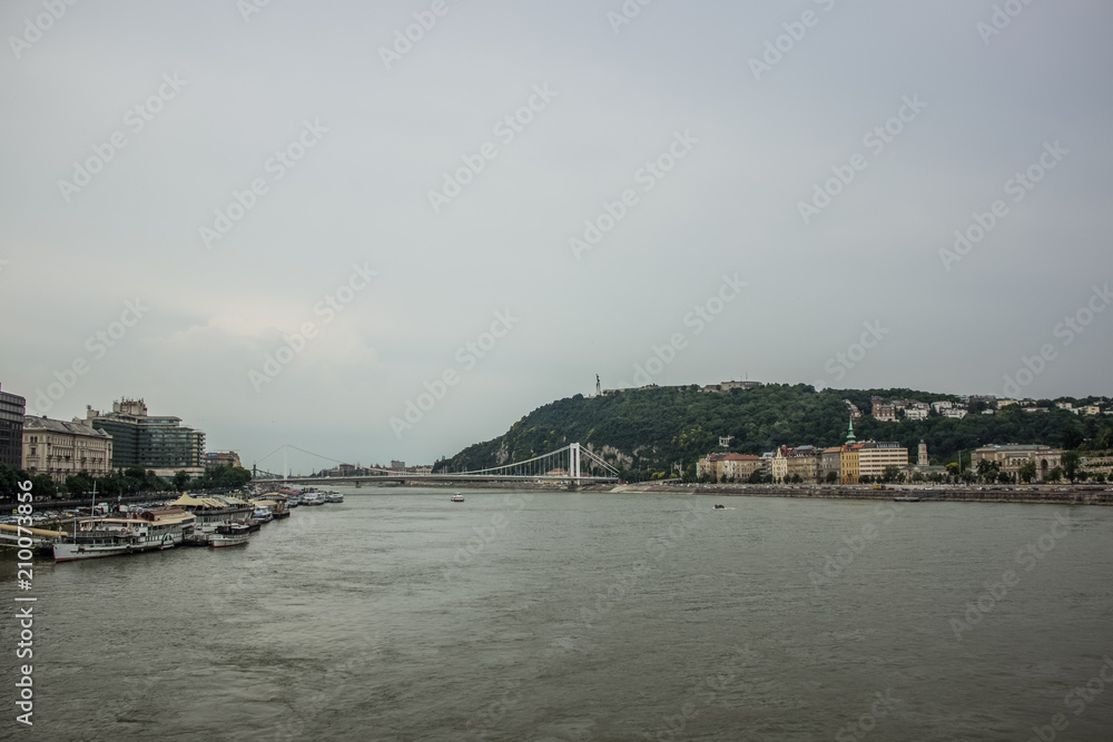 Budapest waterfront in gray rainy day time with river and ships