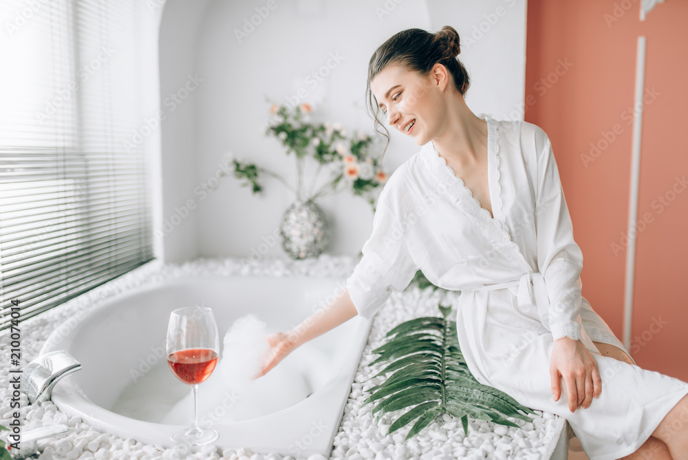 Young woman in n white bathrobe, bathroom interior Young woman in n white bathrobe, bathroom interior
