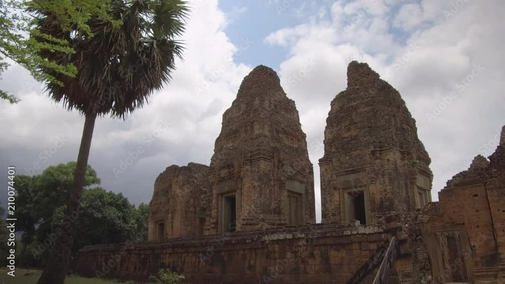 Walking along the stone walls of decaying ancient Buddhist temples in Cambodia, hidden in remote forest. Spectacular shot of big temple complex from ancient times. Beautiful forgotten old buildings. Walking along the stone walls of decaying ancient Buddhist temples in Cambodia, hidden in remote forest. Spectacular shot of big temple complex from ancient times. Beautiful forgotten old buildings.
