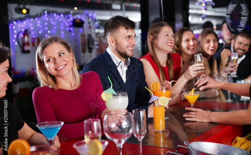 Woman with colleagues enjoying corporate party in bar