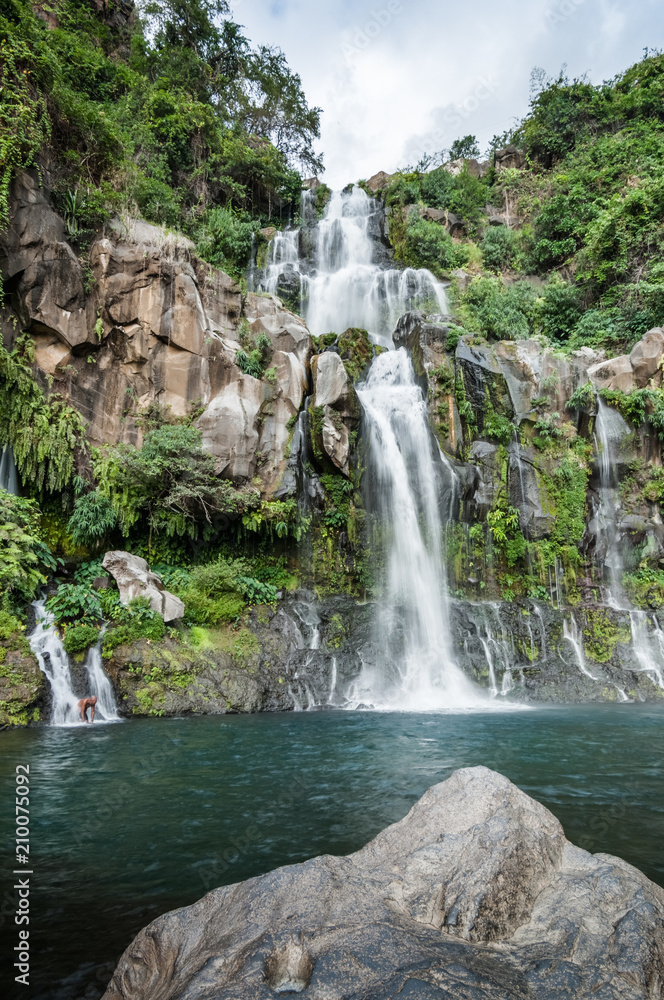 Obraz premium Tropical Cascade Waterfall with Pool Basin in Green Nature and Swimming