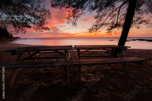 wooden table by the beach during sunset with long expose effect.