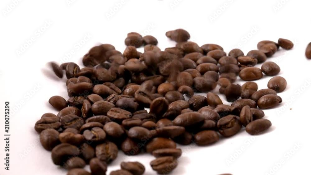 Coffee beans falling on the white table Coffee beans falling on the white table
