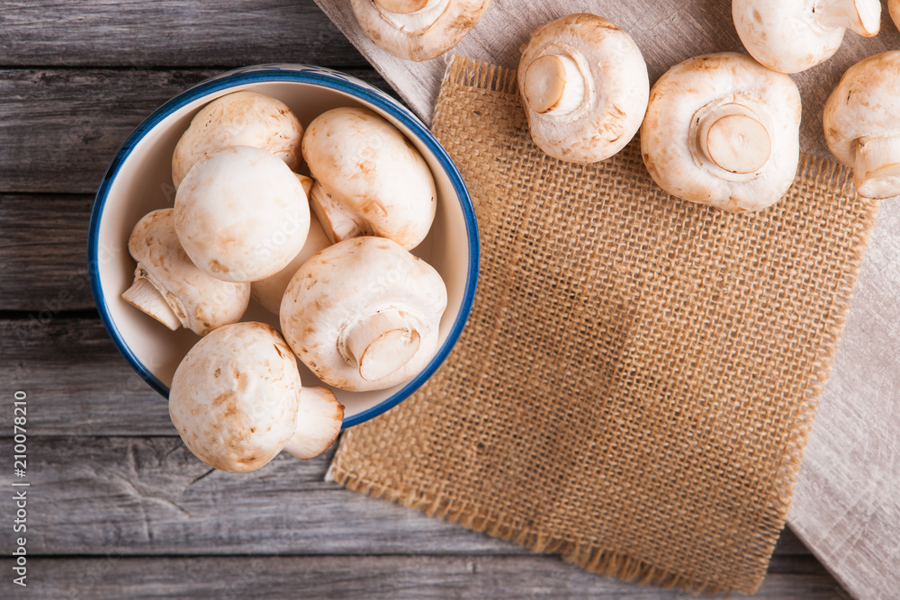 Fresh champignons on a cutting board and in a bowl 