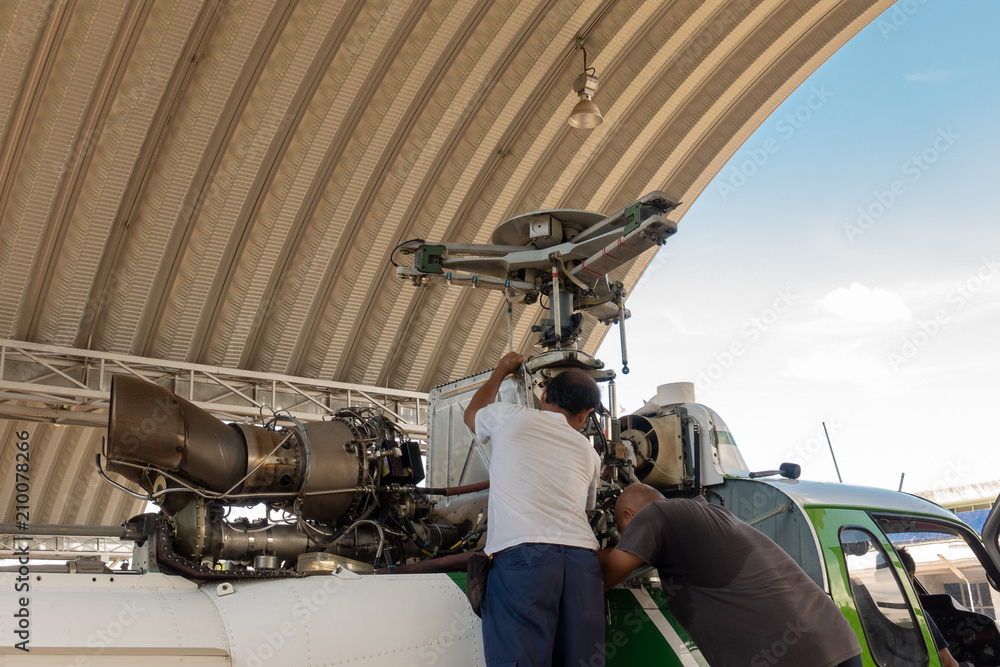 Fototapeta premium Engineer maintaining a helicopter Engine on the aircraft factory