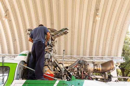 Engineer maintaining a helicopter Engine on the aircraft factory