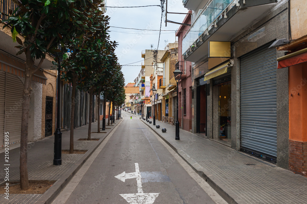 Fototapeta premium Street in Calella in Catalonia, Spain near Barcelona. Scenic old town with sand beach and clear blue water. Famous tourist destination in Costa Brava, perfect place for holiday and vacation