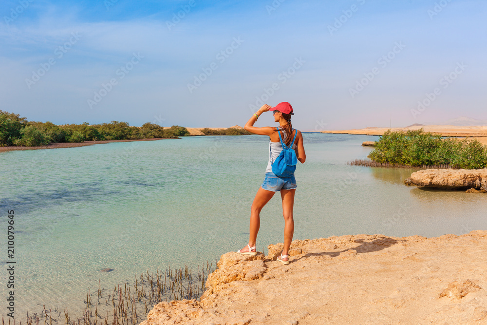 Tourist woman at the Red Sea coast and mangroves in the Ras Mohammed National Park. Famous travel destionation in desert. Sharm el Sheikh, Sinai Peninsula, Egypt.