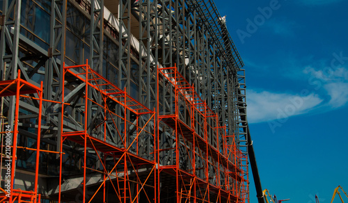 Cuadro en lienzo Vibrant orange falsework and a crane on the background taking part in renovating the building