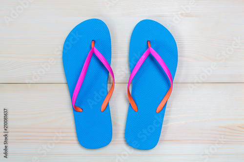 Blue flip flops isolated on wooden background. Top view