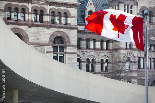 Photography Beautiful Canada flag is waving front of a historical building