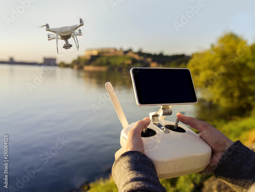 Closeup man hand operating drone by the river