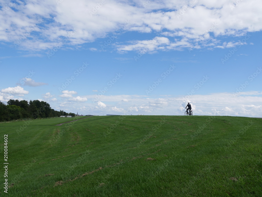 Radfahrer auf einem Berg und Wolken im Hintergrund