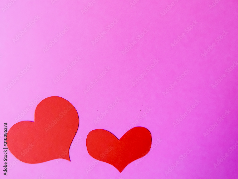 Red paper hearts on a pink paper background