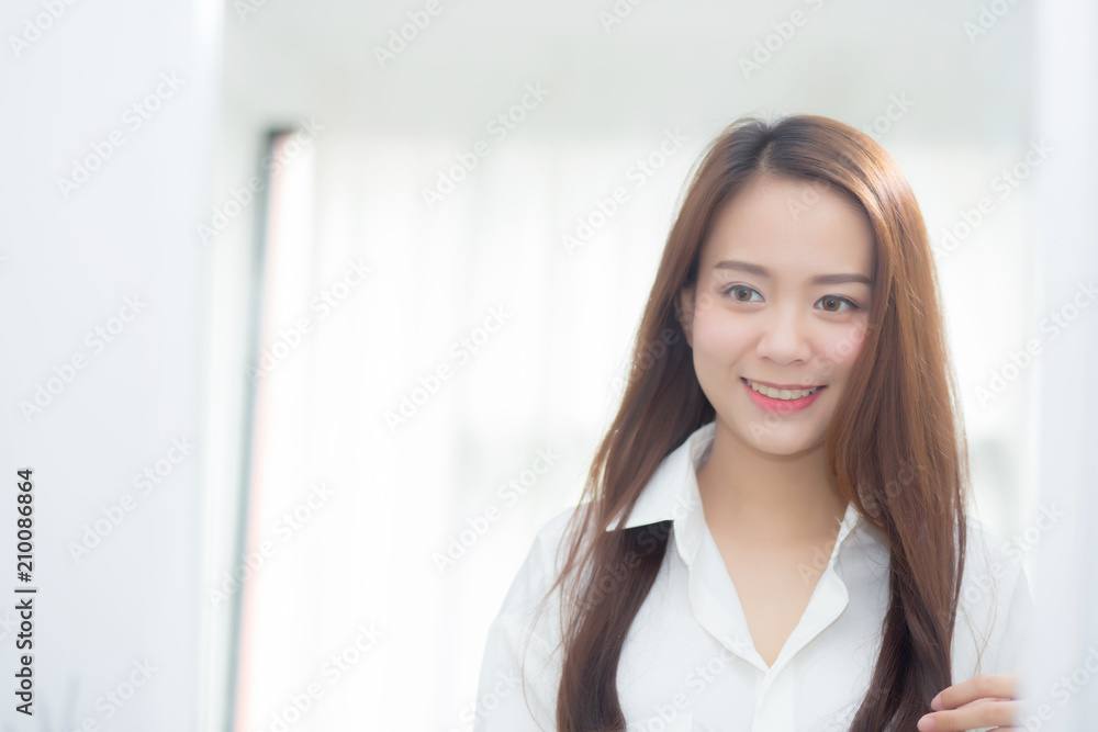 Beautiful of portrait asian young woman examining with face and smile looking on mirror at bedroom, girl beauty of makeup and dressed up with reflection, lifestyle and wellness concept. Beautiful of portrait asian young woman examining with face and smile looking on mirror at bedroom, girl beauty of makeup and dressed up with reflection, lifestyle and wellness concept.