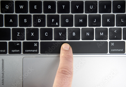 Finger pushing the space bar button of keyboard photo