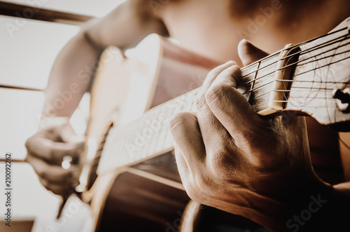The hands of men playing the guitar.