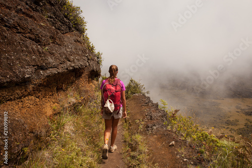 Female hiker on a trail with mist in Hawaii
