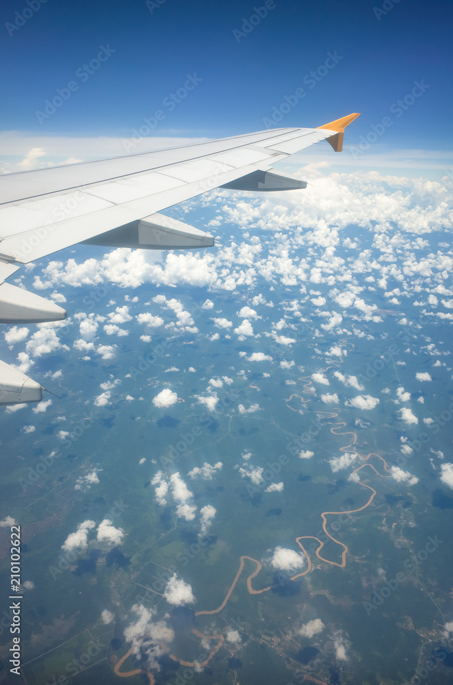 Window Seat View of Plane Wing, Speckled Clouds, and Windy River Window Seat View of Plane Wing, Speckled Clouds, and Windy River