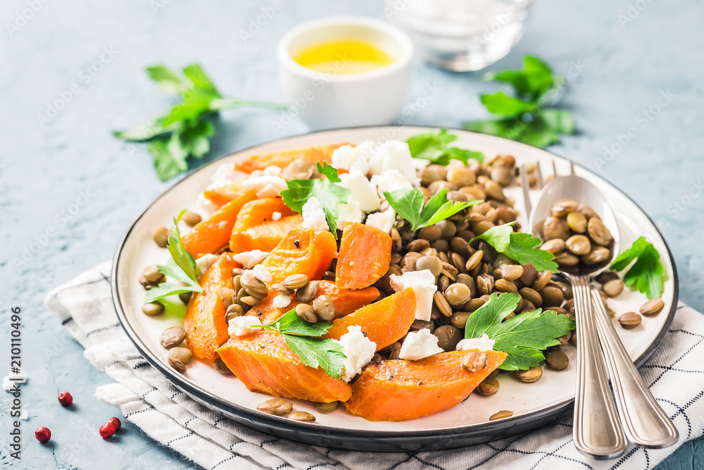 Lentil, roasted vegetables and goat cheese salad on light blue background. Selective focus, copy space. Lentil, roasted vegetables and goat cheese salad on light blue background. Selective focus, copy space.