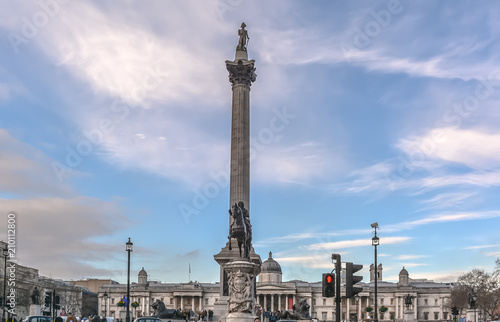 View to the tall Nelson's Column in Trafalgar Square in central London against blue cloudy sky.