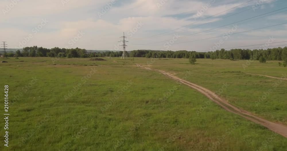 Aerial view. rural road among fields and electric high-voltage supports. countryside road between green field. 4K Aerial view. rural road among fields and electric high-voltage supports. countryside road between green field. 4K