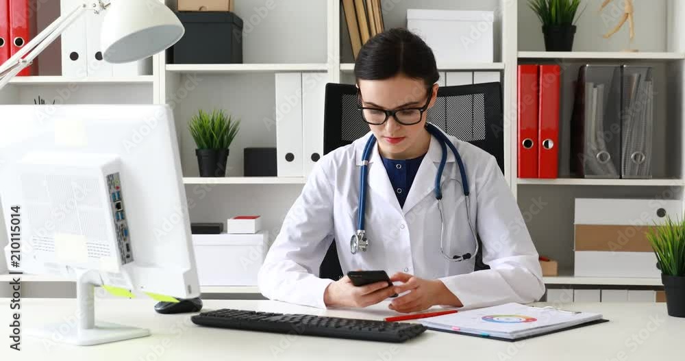 doctor in glasses calls on phone at the workplace doctor in glasses calls on phone at the workplace