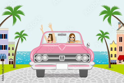 Two women driving a Pink convertible in summer nature - seaside town
