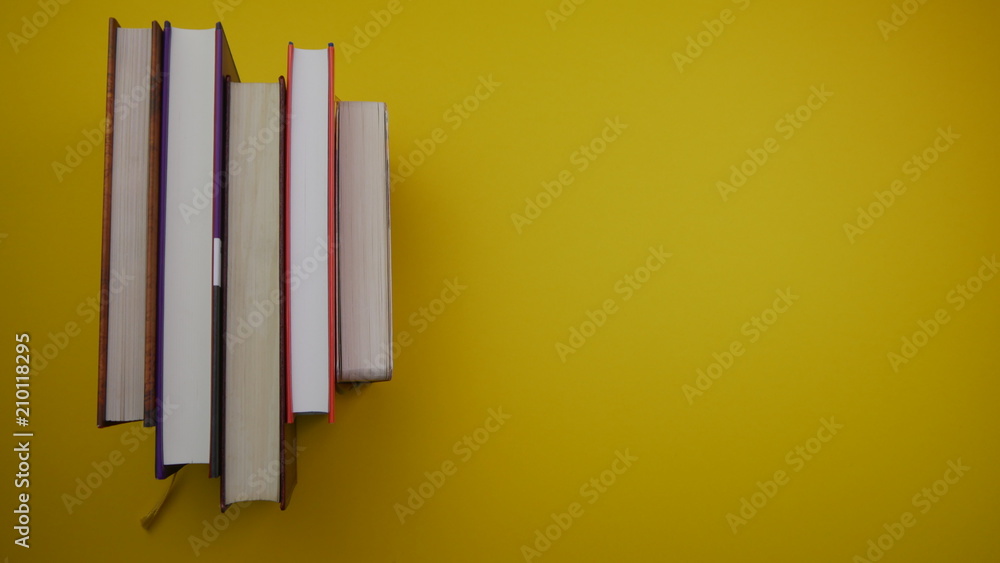 umgedrehte Bücher auf einem gelben Hintergrund mit Platz für beschriftungen umgedrehte Bücher auf einem gelben Hintergrund mit Platz für beschriftungen