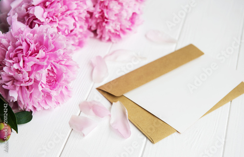invitation card, craft envelope and pink peony flowers