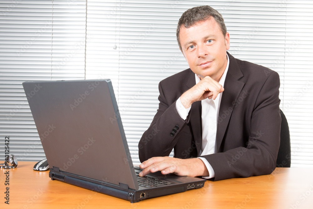Businessman with laptop computer monitor while working in office Businessman with laptop computer monitor while working in office
