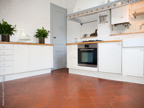 modern white kitchen with antique floor tiles
