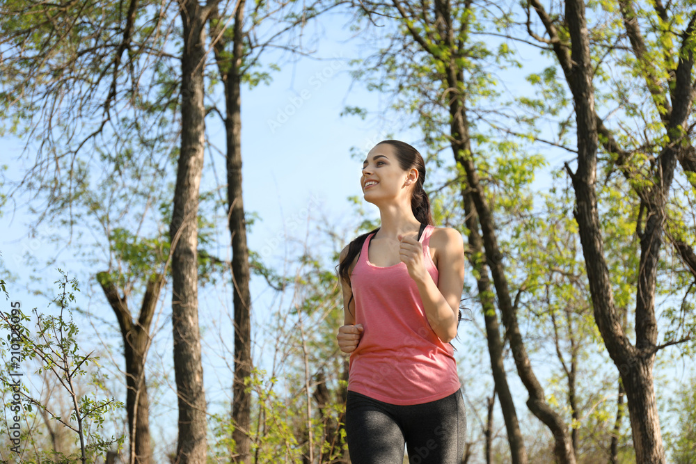 Sporty young woman running in park Sporty young woman running in park