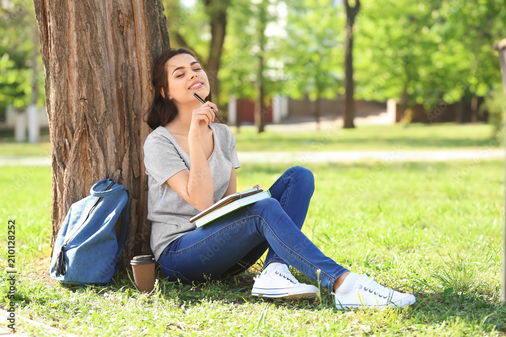 Beautiful young woman with notebook resting in park Beautiful young woman with notebook resting in park