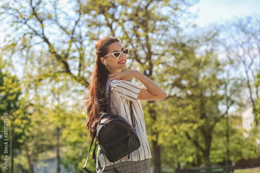 Naklejka premium Beautiful young woman walking in park