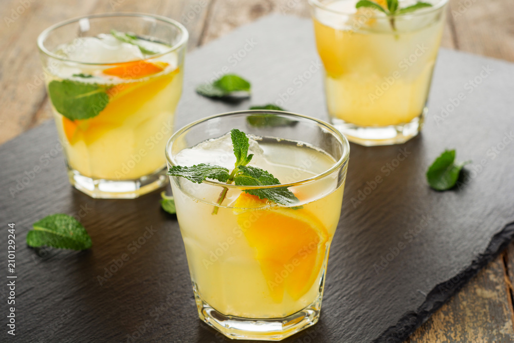 Fototapeta premium Summer drink. Citrus lemonade with mint and ice on white wooden background.