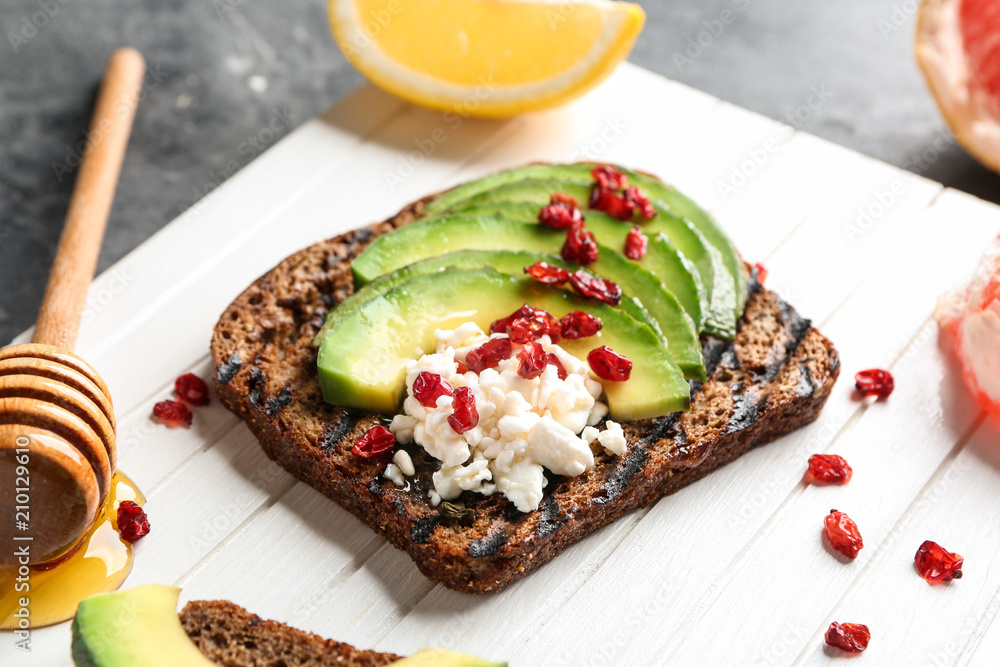 Board with tasty toast on grey background Board with tasty toast on grey background