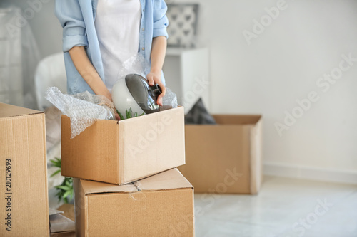 Woman packing carton box in...