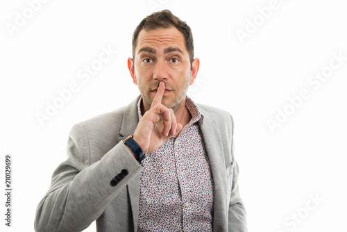 Portrait of business man making silence gesture