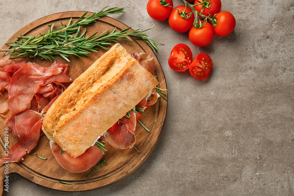 Tasty sandwich with prosciutto on wooden board Tasty sandwich with prosciutto on wooden board