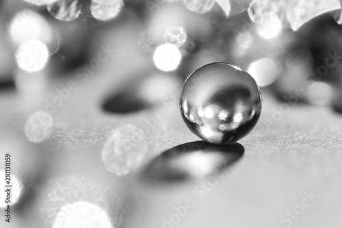 Little glass balls in direct sunlight, macro. Abstract background, black and white photo