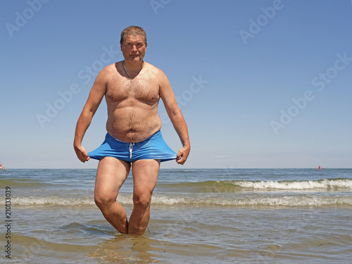 comic portrait of the fat man, doing the breast stroke in a water photo