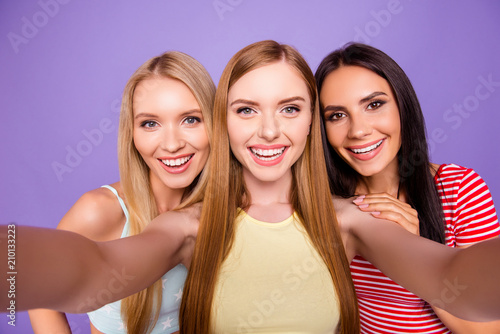 Self portrait of cheerful pretty girls shooting selfie on front camera having leisure isolated on vivid violet background. Vacation weekend rest relax holiday concept
