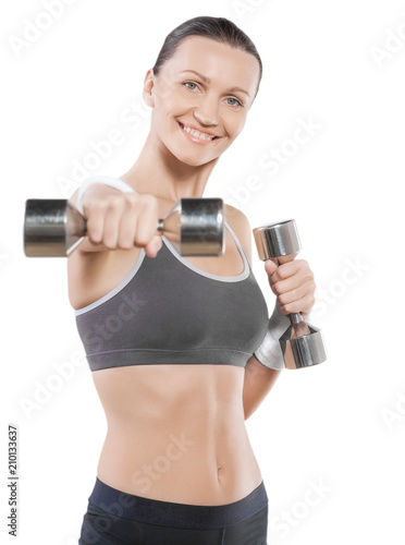a smiling sporty female wearing sports clothes with dumbbells is