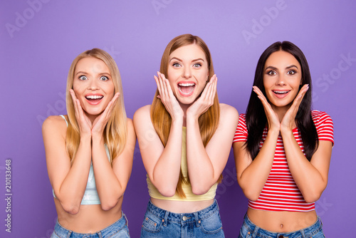 Luck success concept. Portrait of amazed wondered girls holding palms hear cheeks with wide open mouth eyes looking at camera isolated on violet background. Rest relax leisure concept